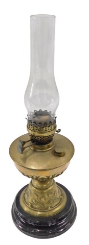 A Victorian brass oil lamp, with an Art Nouveau flower and vine reservoir on a circular ebonised base, with funnel, 54cm high.