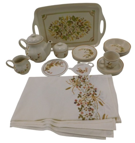 A St Michaels Harvest pattern part tea service, comprising serving tray, teapot, milk jug, sugar bowl, one teacup, teapot stand, four small plates, four saucers, and four bowls, associated tray, and a table cloth.
