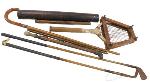Various hickory shafted and wooden handled golf clubs, a special tournament tennis racket, a brass garden sprayer, walking stick, and a carved hardwood didgeridoo.