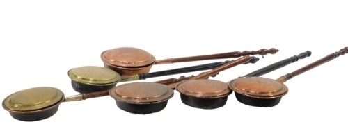 Six 19thC and later copper and brass warming pans and chestnut roasters, each with a turned wooden handle, 110cm long. (6)