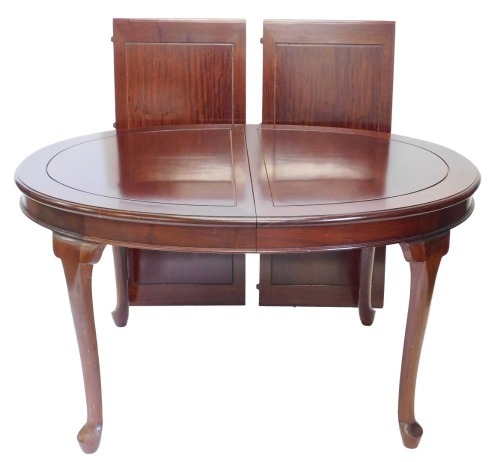 An Oriental hardwood extending dining table, the oval top with a moulded edge on cabriole legs, and pad feet, two loose leaves, 76cm high, 113cm wide, 244cm long.