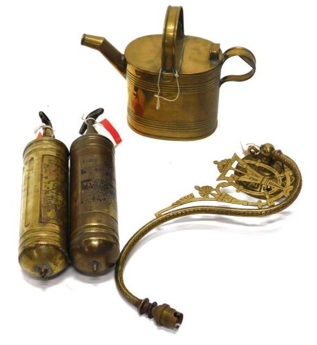 A brass watering can and other brass, including two fire extinguishers, and a brass scroll lamp bracket of aesthetic design.