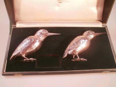 A pair of George V silver condiment castors in the form of kingfishers