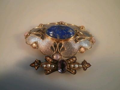 A silver and pearl pierced brooch with central lapis lazuli cabochon