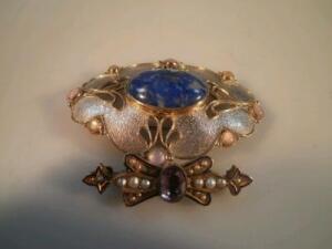 A silver and pearl pierced brooch with central lapis lazuli cabochon