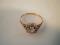A floral cluster ring set with a central diamond of 0.10pt approx surrounded