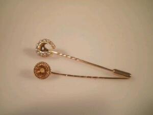 A horseshoe shaped seed pearl set stick pin and another set set