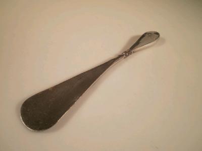 A silver handled shoe horn with monogrammed handle