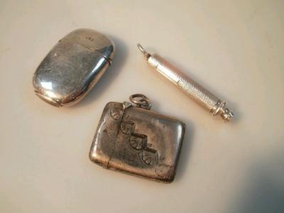 Two silver vesta cases and a silver propelling pencil