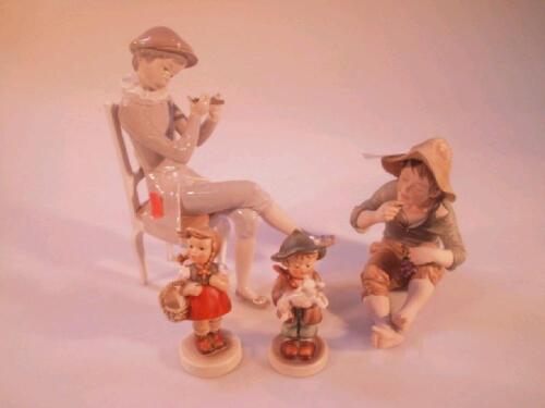 A Capo di Monte porcelain figure of a seated boy eating grapes
