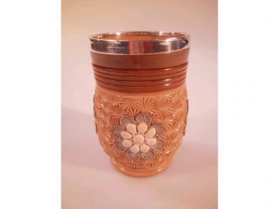 A Doulton Lambeth stoneware vase with a ribbed neck and relief moulded flowerhead designs