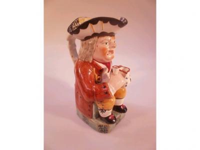 A 19thC Staffordshire Toby Jug with figural handle decorated in brown
