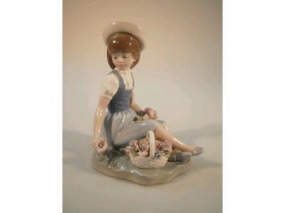 A Lladro figure of a seated girl with a basket of flowers