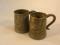 A pair of 19thC Chinese pewter tankards with glass bottoms and embossed