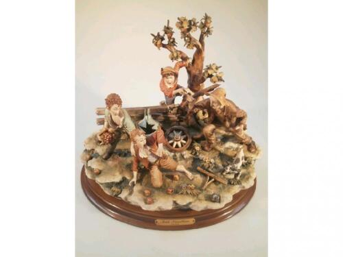 A large Capo-di-Monte figure group depicting a man chasing three young scrumpers