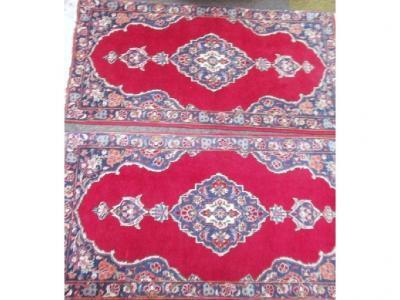A pair of red ground floral design Persian rugs