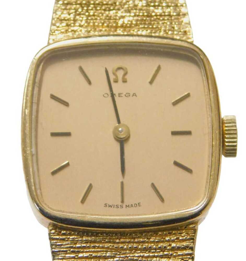 A 9ct gold Omega wristwatch, the square watch head with batoned dial ...