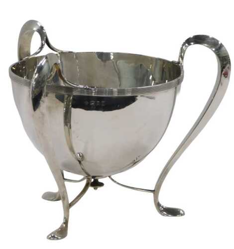 An Edward VII silver Art Nouveau Champagne bucket, by H Wilkinson & Co, on stylised three...