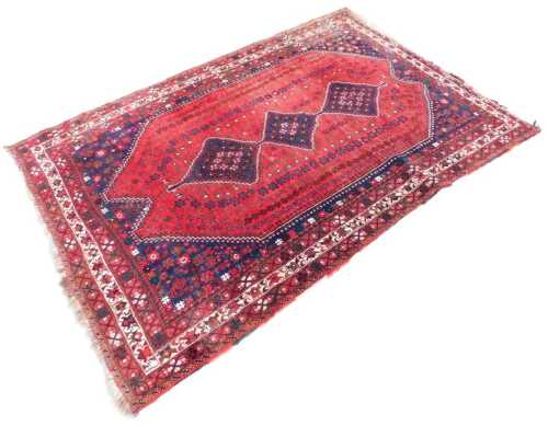 A 20thC hand knotted Persian wool Hamadan style rug, with a geometric diamond centre and outer...