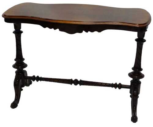 A mid Victorian walnut side table, with serpentine sides and a quarter veneered top, raised on...