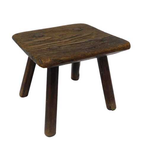 A late 19thC elm milking stool, of square form, on turned legs, 21cm high, 25cm wide, 24cm deep.