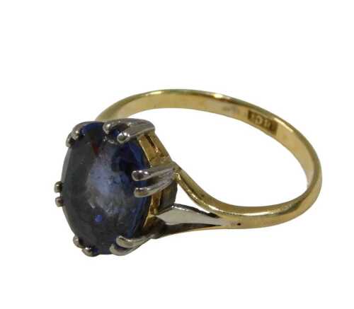 A lady's dress ring, claw set with blue stone, on a part pierced shank marked 18ct, ring size L,...