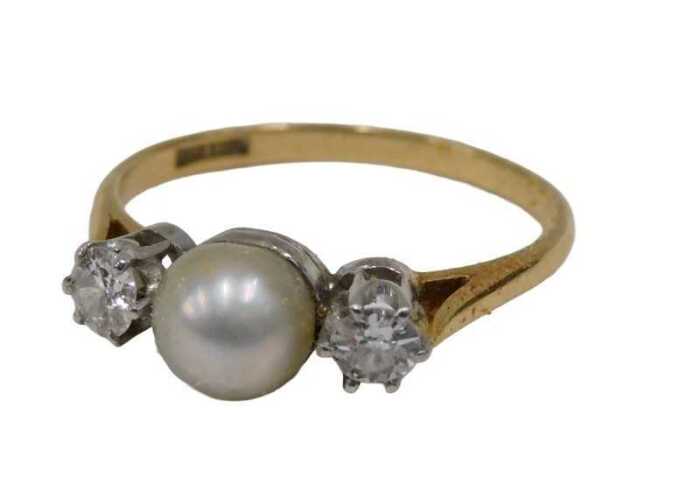 A pearl and diamond three-stone dress ring, with single cultured pearl to centre flanked by two...