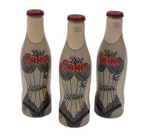 Three John Paul Gaultier design Coca-Cola bottles, unopened with contents, 19cm high.