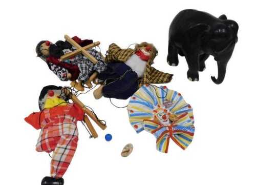 An ebonised standing elephant figure, 16cm high, various clown and other puppets Pelham style,...