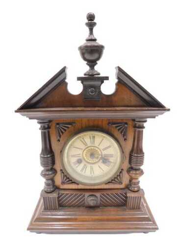 An Edwardian walnut mantel clock, the 12cm diameter Arabic dial flanked by quarter columns, in a...