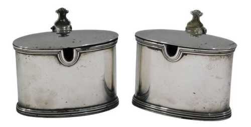 A matched pair of George V silver mustard pots, by Garrard & Co, with shell capped thumb mould,...
