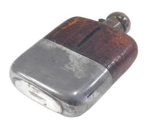 An early 20thC crocodile finish and silver plated hip flask, with orb lid, shouldered body and...