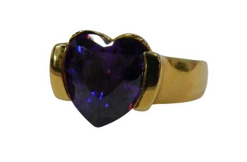 An amethyst dress ring, set with fancy cut heart amethyst in a tension raised setting, on a gold...