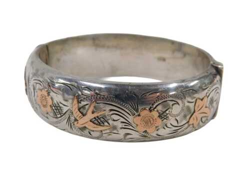 An Edwardian silver half hinged bangle, with raised relief bicolour detail of swallow and...