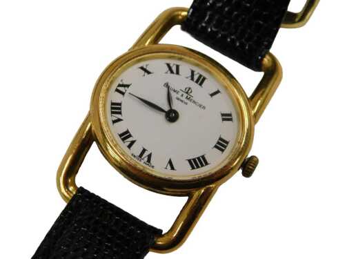 A Baume and Mercier 18ct gold lady's wristwatch, the oval buckle dial on a white ground with...