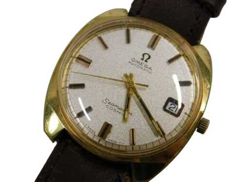 An Omega Seamaster Cosmic gent's wristwatch, in a gold plated case with silvered strap, on brown...