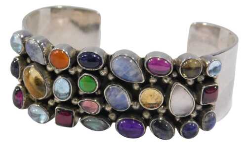 A multi-stone link bangle, the rectangular bangle set with tear drop oval and square cut...