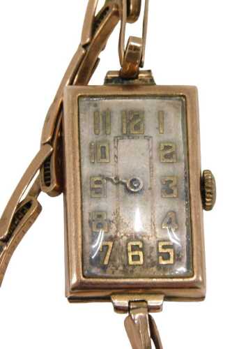 A 9ct gold cased ladies Art Deco style wristwatch, the rectangular watch head on silver ground,...