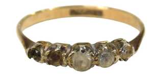 A five stone dress ring, set with four imitation diamonds, one missing, in a rub over platinum...