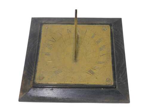 An early 20thC brass sundial, on oak mount, 16cm high.