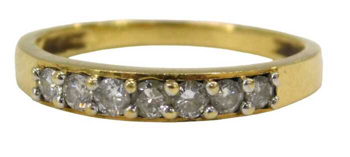 An 18ct gold diamond half hoop dress ring, set with seven round brilliant cut diamonds, each...