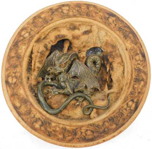 A Studio pottery wall plaque, dragon in naturalistic setting, 33cm diameter.