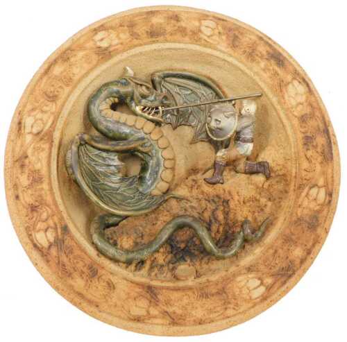 A Studio pottery wall plaque, figure slaying dragon, 33cm diameter.