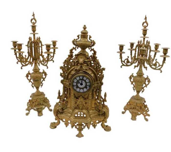 A 20thC gilt metal clock garniture, the 9cm diameter raised enamel Roman numeric dial housed in...