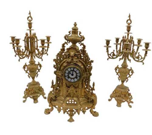 A 20thC gilt metal clock garniture, the 9cm diameter raised enamel Roman numeric dial housed in...