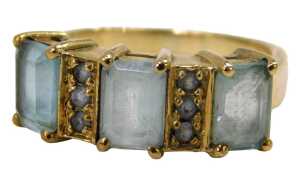 A 9ct gold dress ring, set with rectangular cut aquamarines and six round brilliant cut pale...