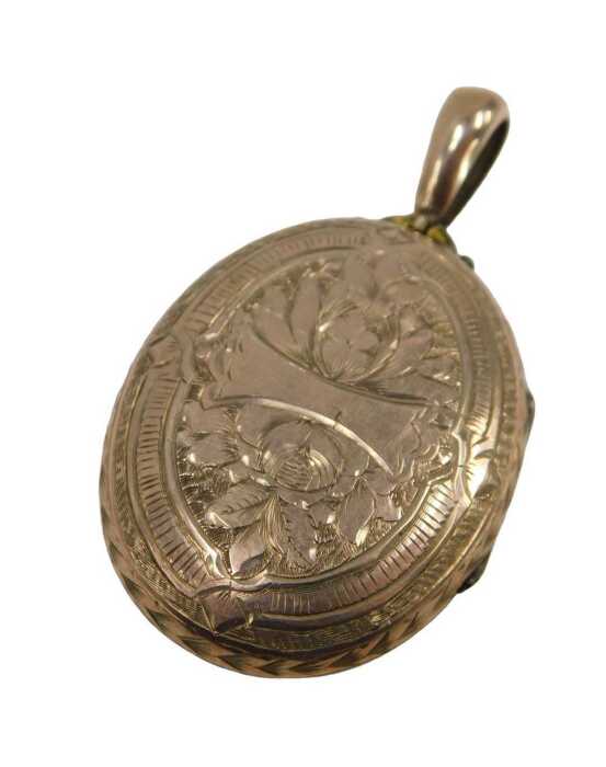 An early 20thC rolled gold locket, heavily engraved with flower and leaf detail, with a pendant...
