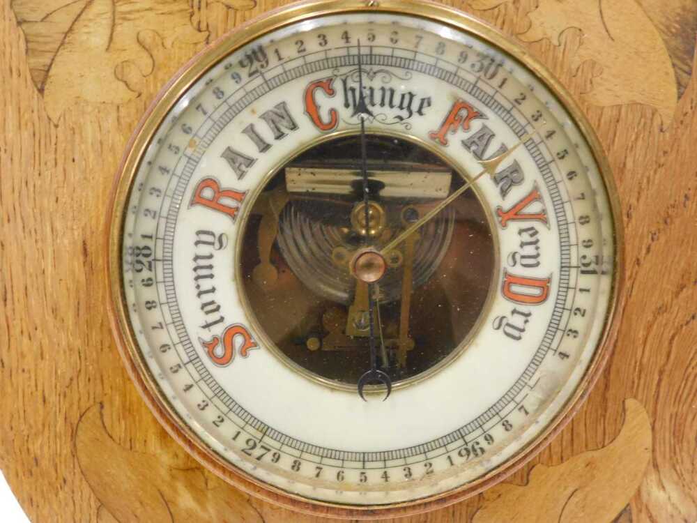 An early 20thC oak and marquetry aneroid barometer and thermometer, in ...