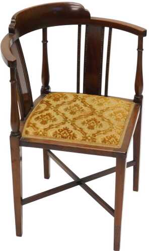 An Edwardian mahogany corner chair, with overstuffed seat in gold material, terminating in...
