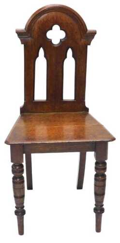 A late 19thC Gothic style oak hall chair, with pierced back, turned front legs, 89cm high.